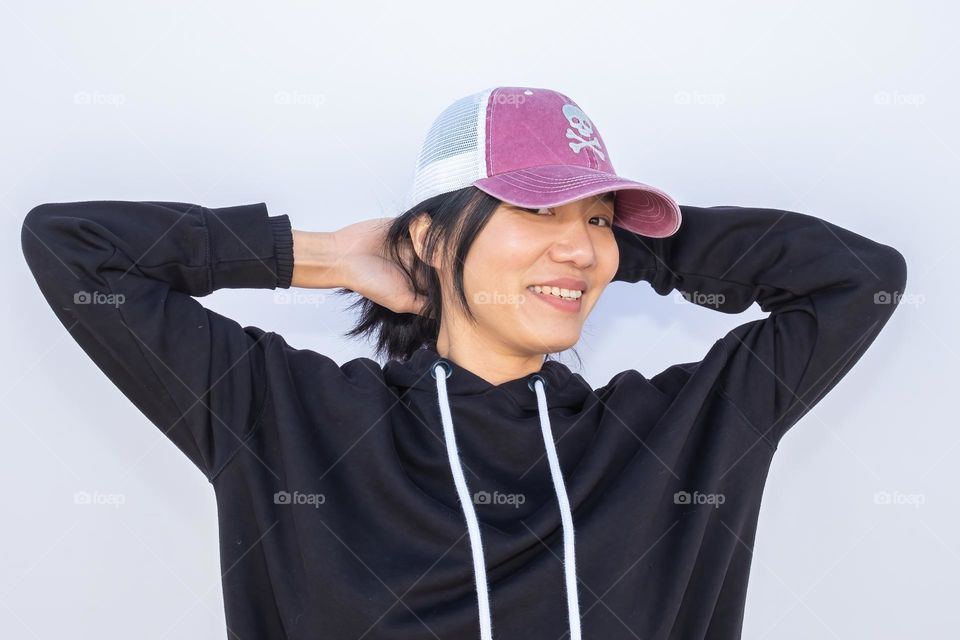 A young lady of Taiwanese descent has fun showing off her sparkly cap. 