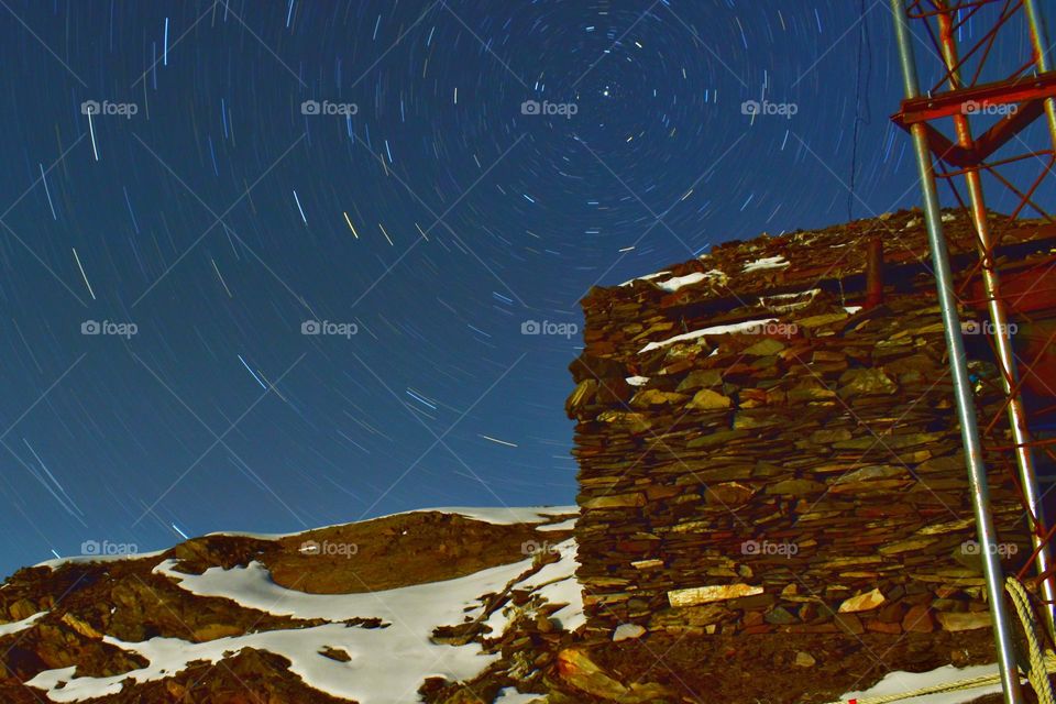 North pole star and trails with abandoned building in foreground