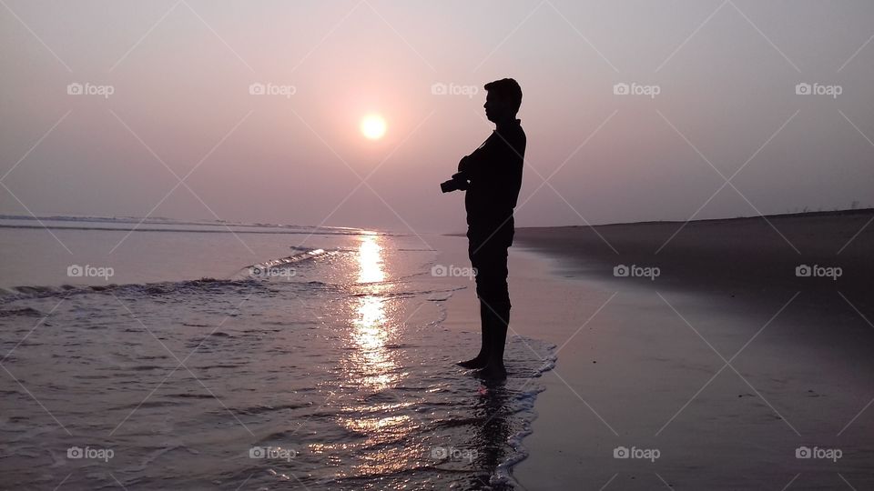photographer enjoying sunset in sea Beach