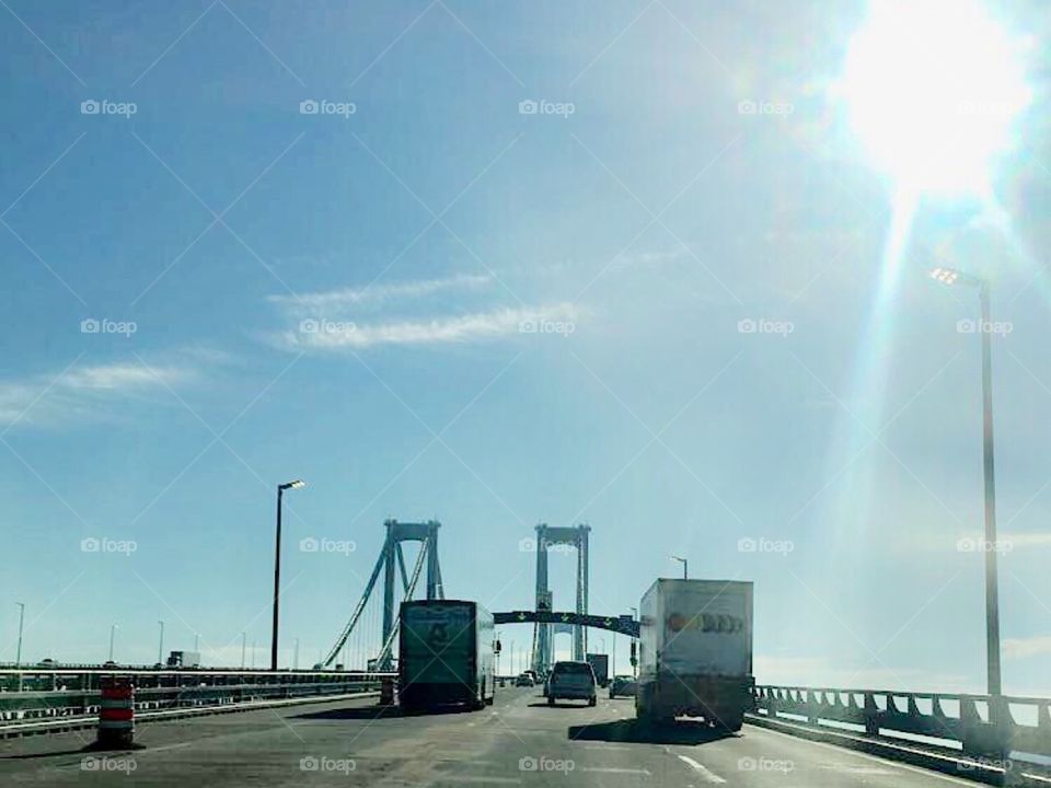 Cars and trucks driving on a bridge on a sunny day