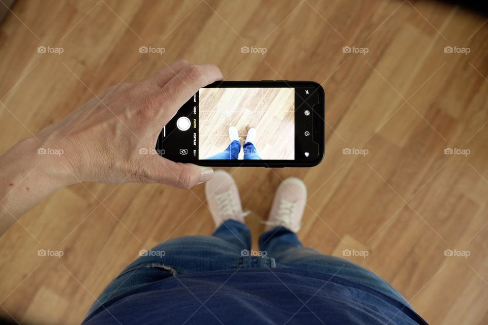 Woman using iPhone to take photographs, taking photos to sell digitally, using Foap to make money selling photos, selling smartphone photos to companies for ads, selling photographs online, selling photographs digitally through the Foap app