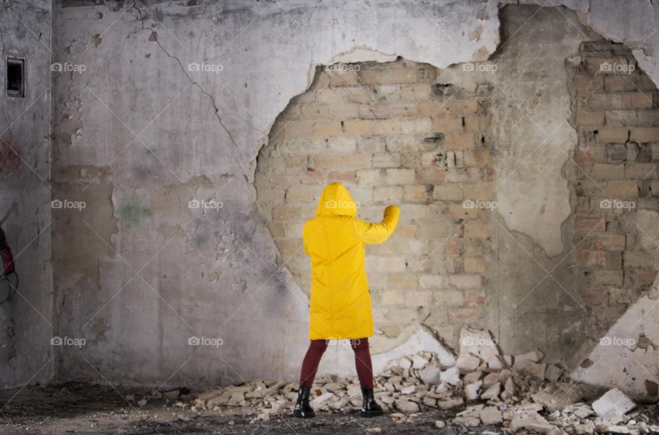 Woman power against a wall