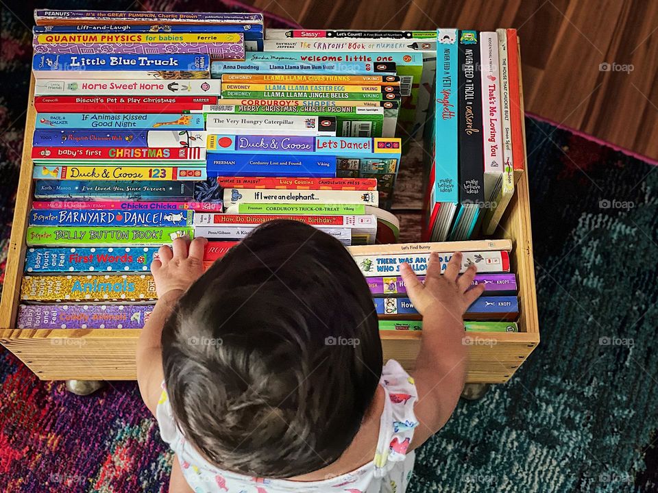 Happiness is reading books, baby is happy looking at all of her books, baby is happy about reading time, baby loves her board books, colorful books bring cheer to baby 