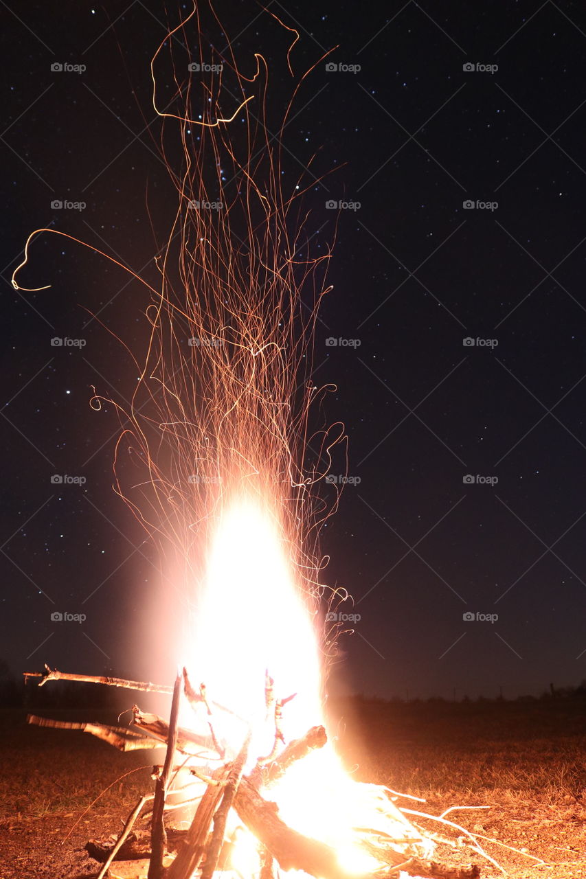 A bright blazing fire under an open starry night.