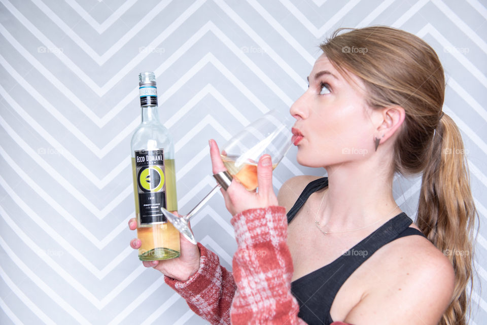 Millennial woman drinking a glass of Ecco Domani wine 