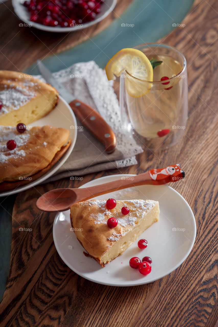 Cheesecake with cranberries and sugar on wooden background