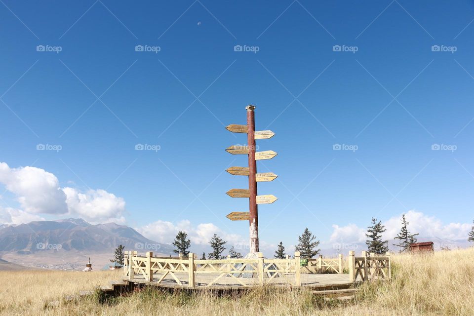 Direction crossroad sign showing distance between cities in China. Signpost. Travel vacation concept-blue sky, white clouds, at Zhou'er Moutain, Qinghai, China.
