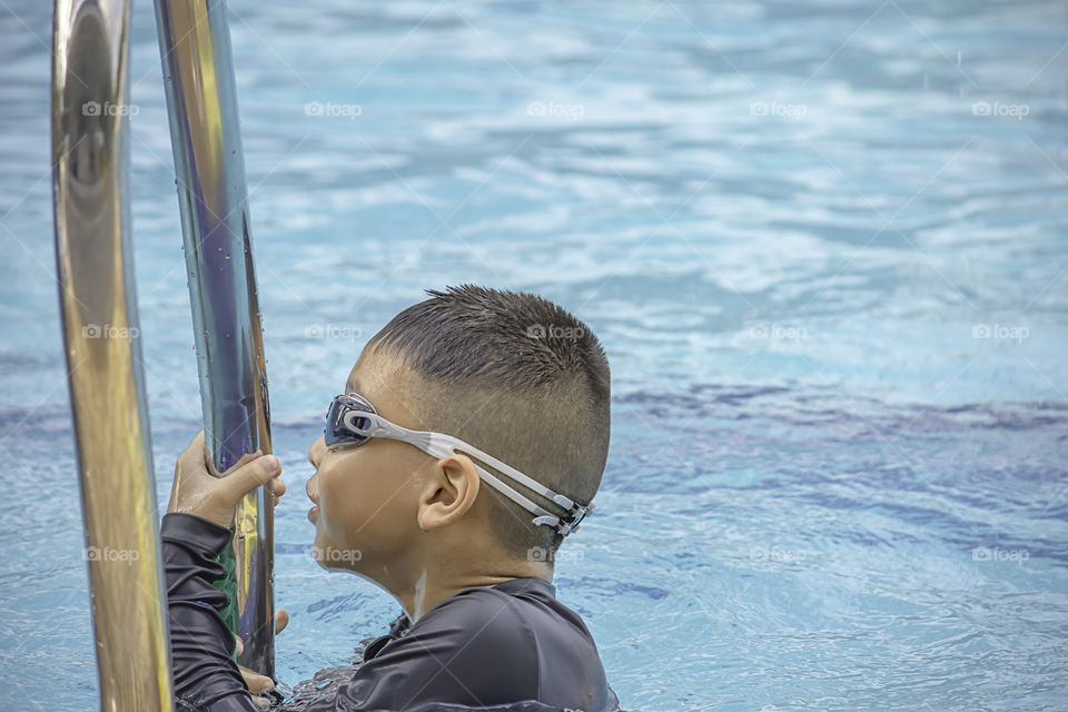 Asean boys are swimming in the pool.