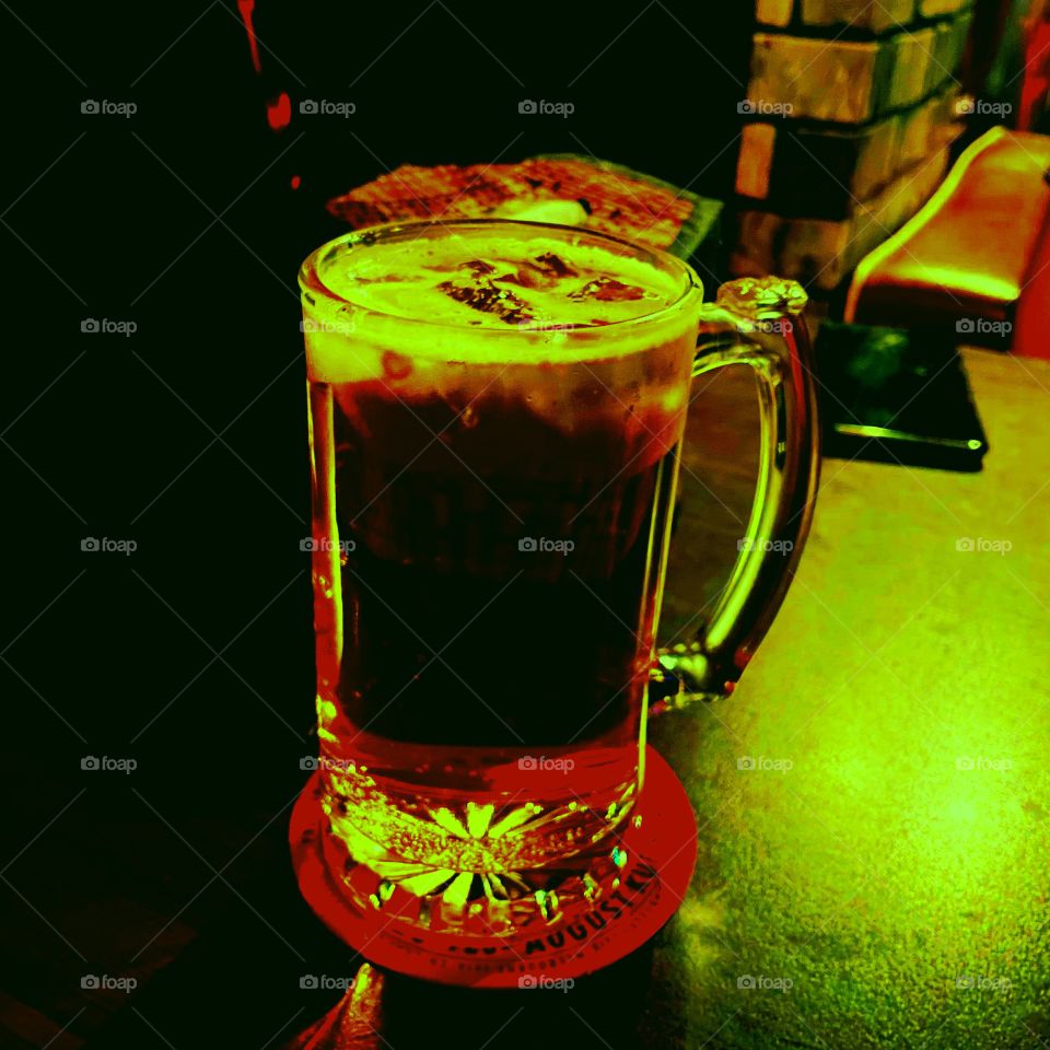 A glass of green and red beer. It is a classic mug with green and red lights. 