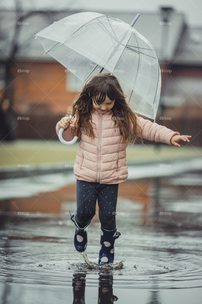 Little girl have fun under the rain.