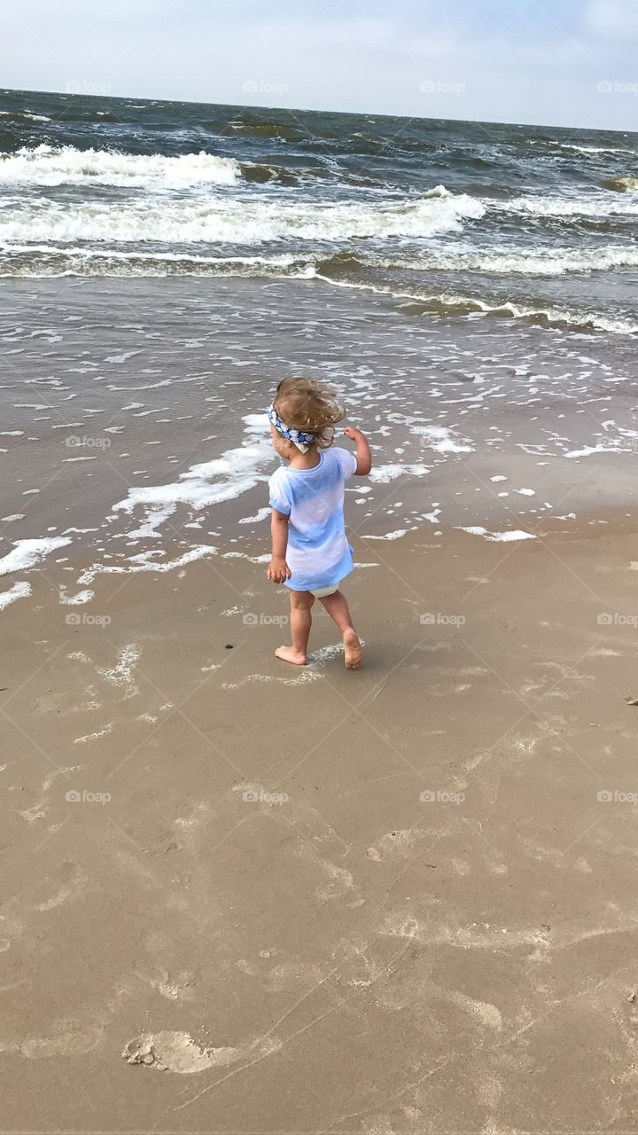 Small girl running on the beach 