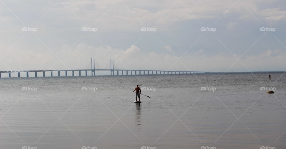 Stand up paddle boarding by the Öresund bridge, Malmö Sweden.