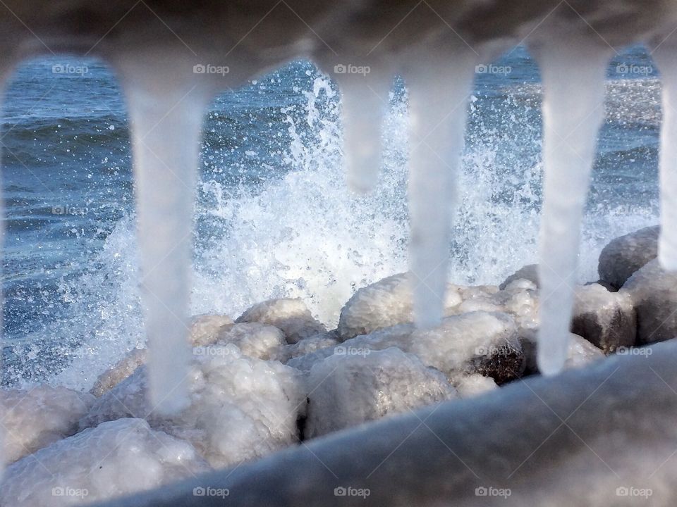 Splashing water through icy railing 