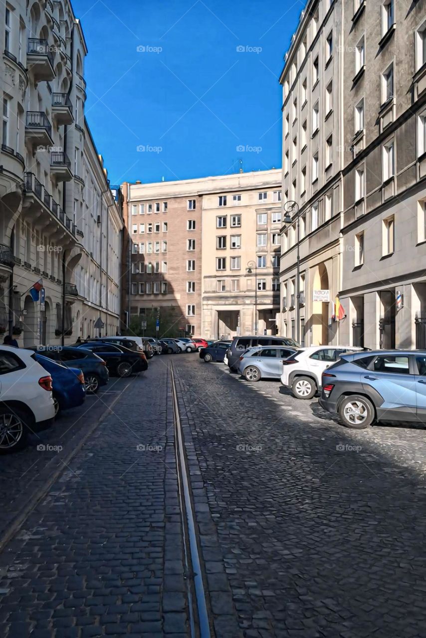 "Cobblestone Street with Parked Cars in Urban City