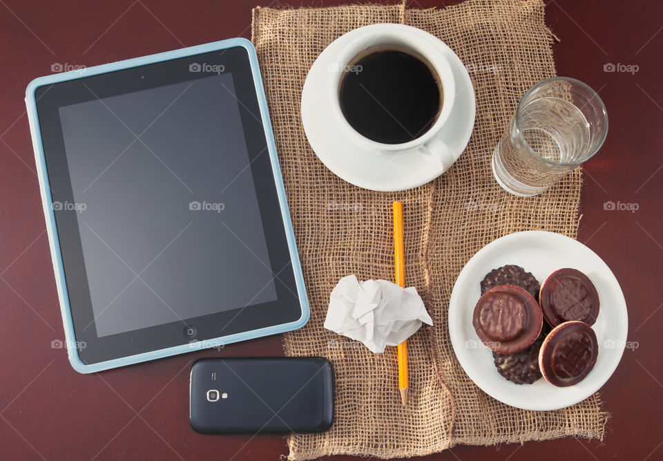 Mobile devices on the table. Top view of mobile devices and coffee cup on the table