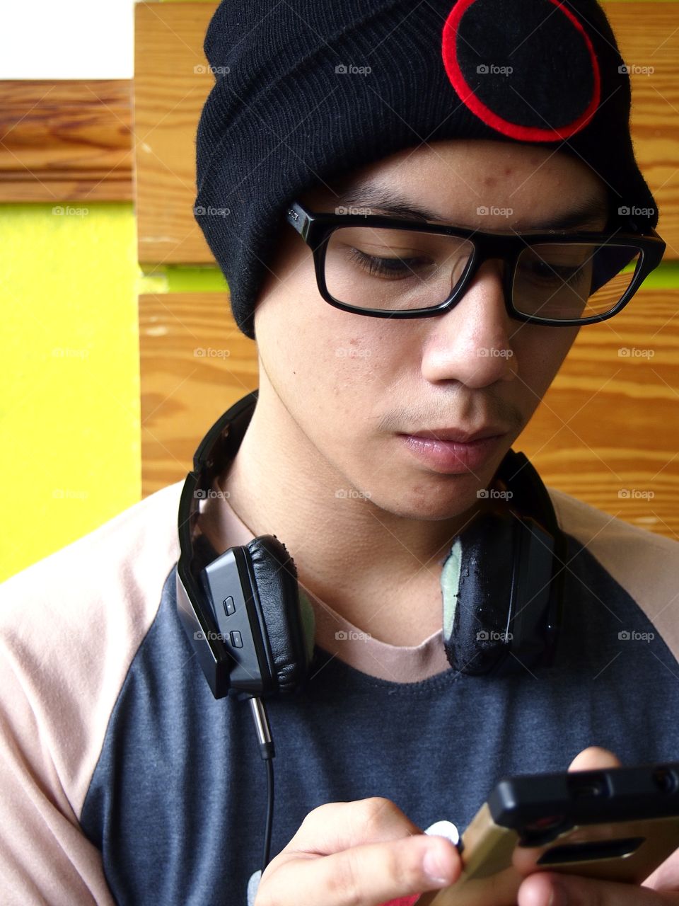teenage boy wearing bonnet using a smartphone