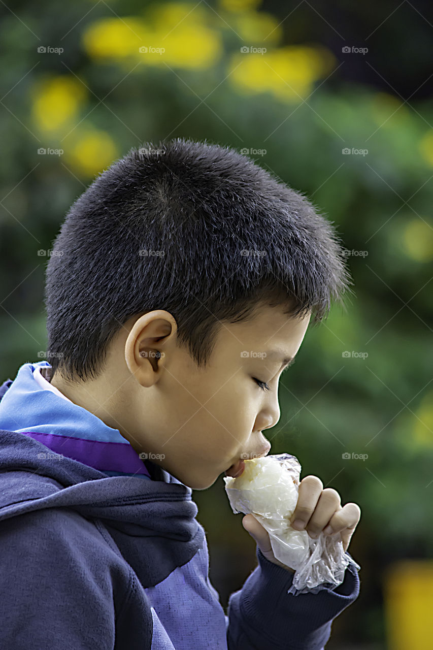 Asian boys are eating sticky rice.