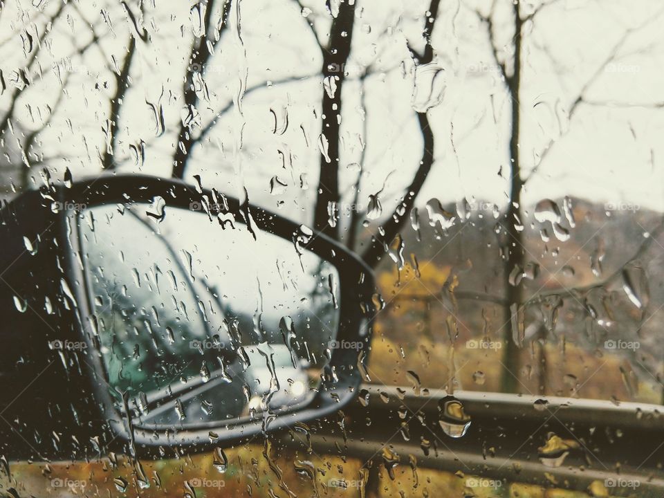 Rear mirror of the car during rainy day. View from the car. Slovakia
