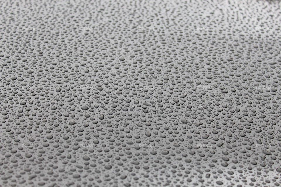 Tiny drops of rain on a gray metal surface.  Textured effects
