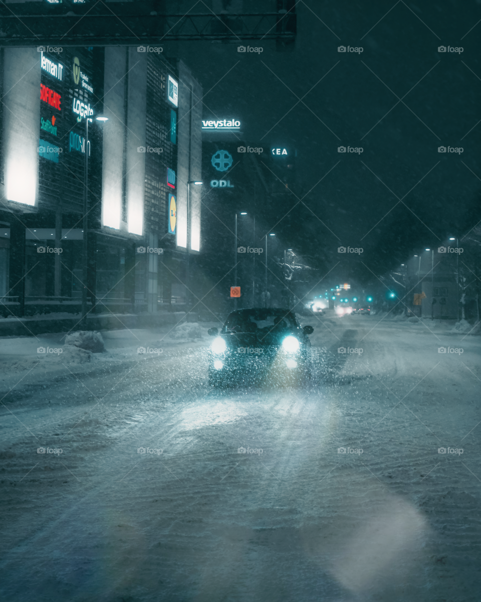 Car in snowstorm at night cityscape