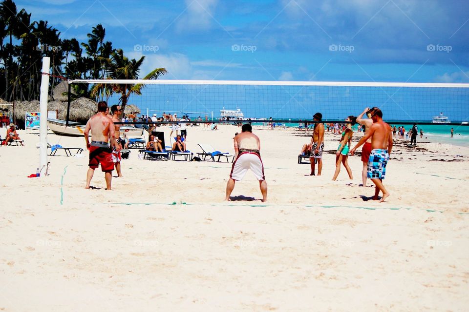 Crowd playing volleyball on the beach