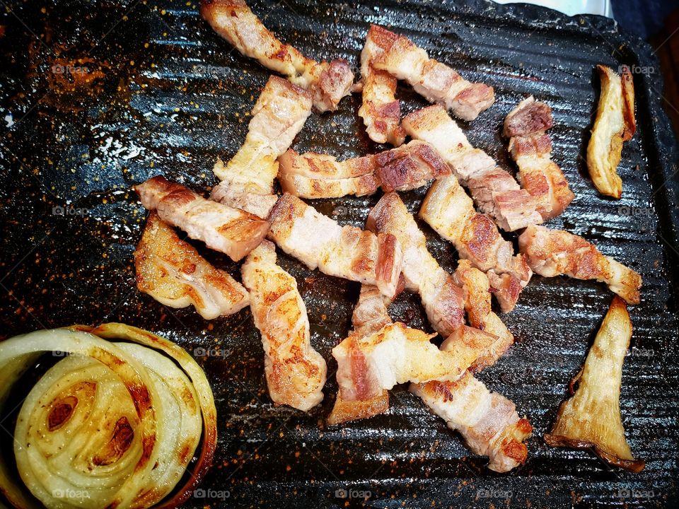 Pork belly strips fried on a Korean-style grill or pan.