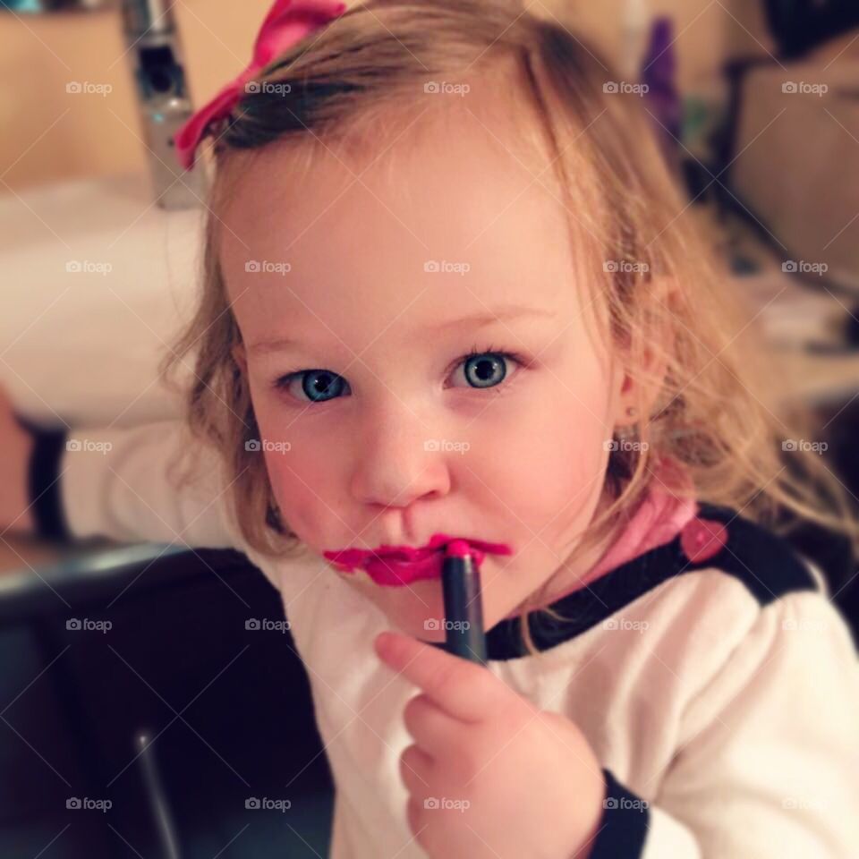Portrait of a little girl with messy lipstick