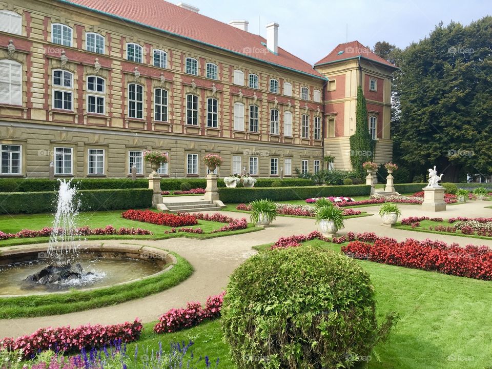 Romantic Castle in Lancut, Poland with surrounding flower garden in the summer. 