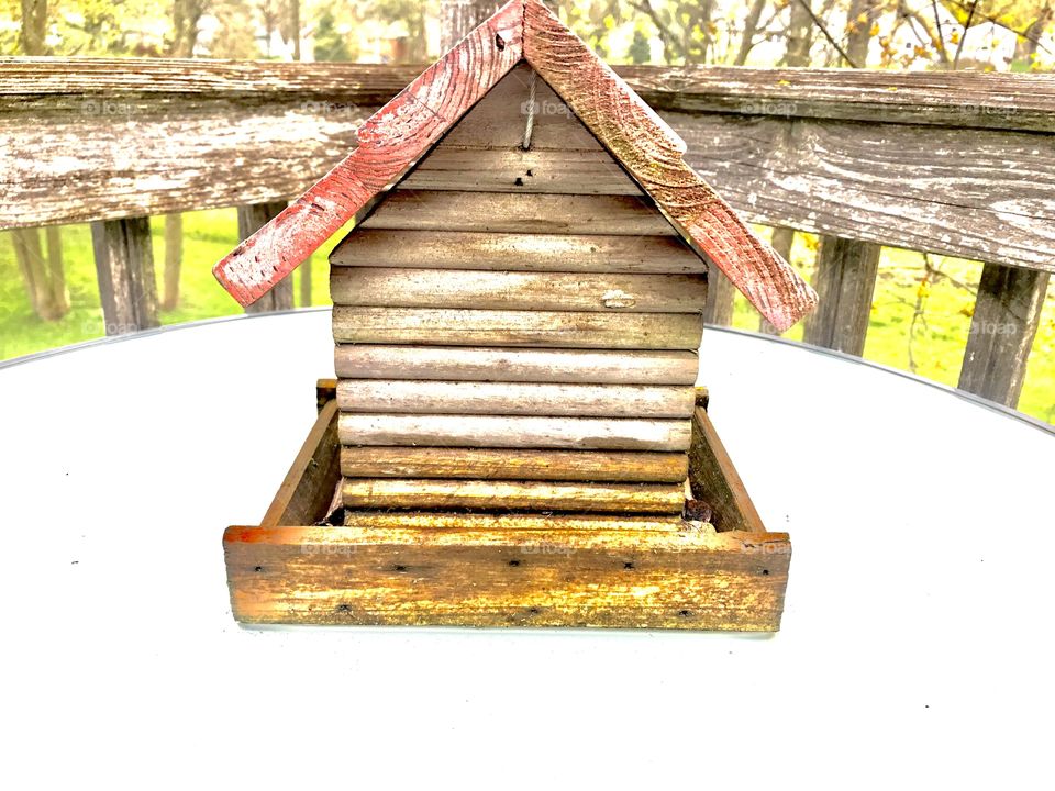 Wooden birdhouse sitting on table makes for a fun setting to snap a couple of photos. 