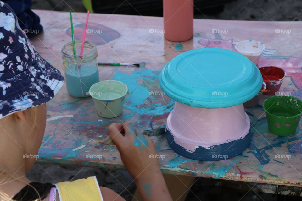 Girl painting , choosing carefully bright colours, creating her masterpiece.. colours all over the table , her hands too .. nevertheless she really enjoys it 😉