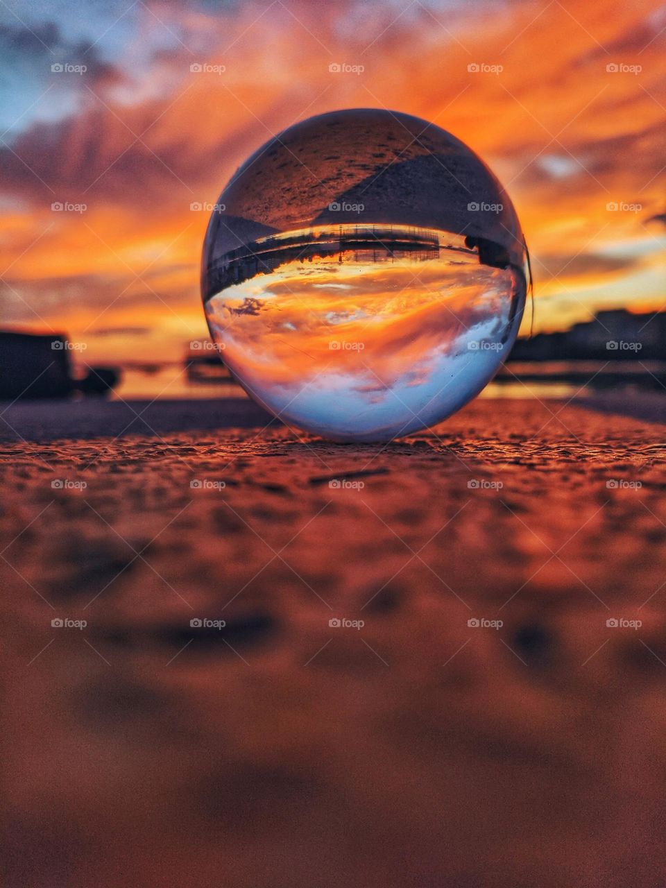 Ground up photo of the lens ball, crystal ball reflected in the road at the red sunset light