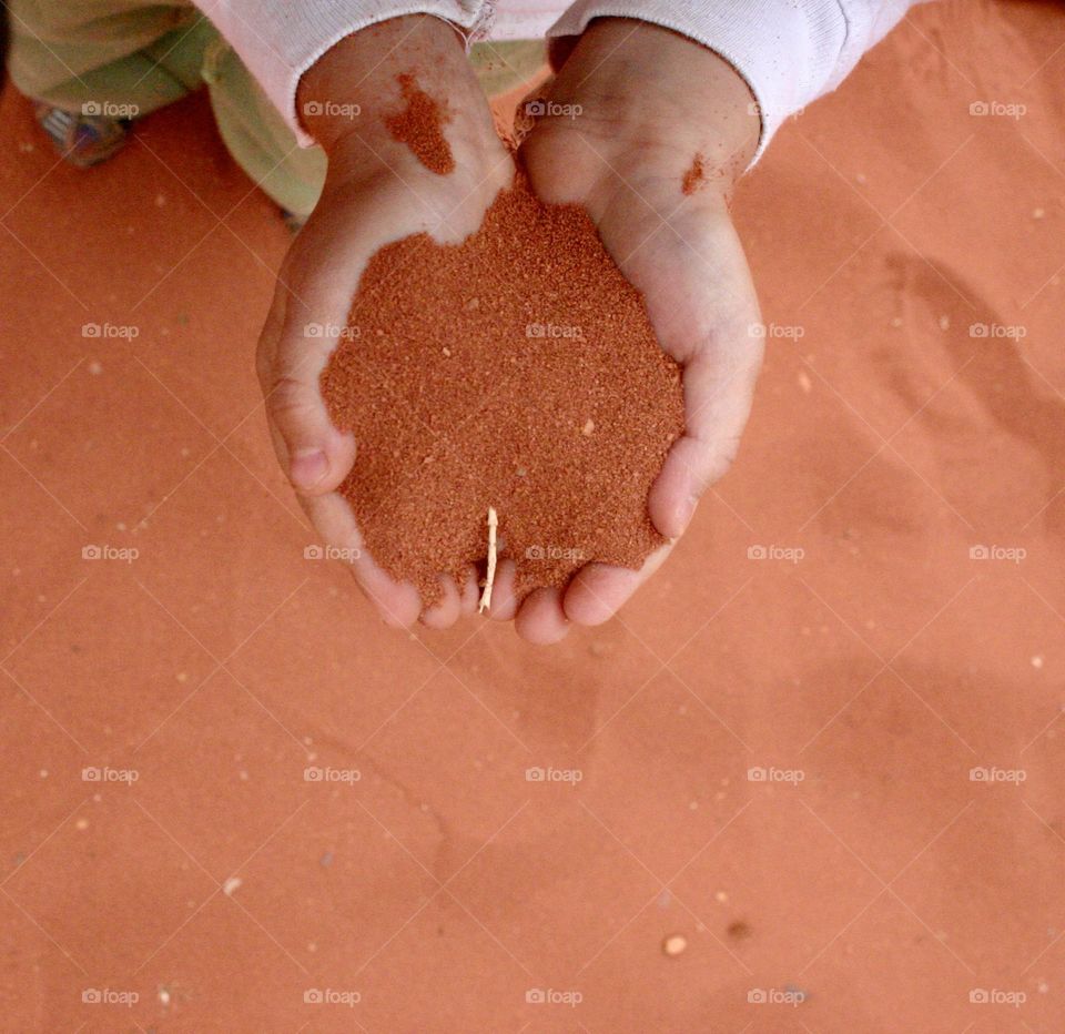 Red sand in a boy hands
