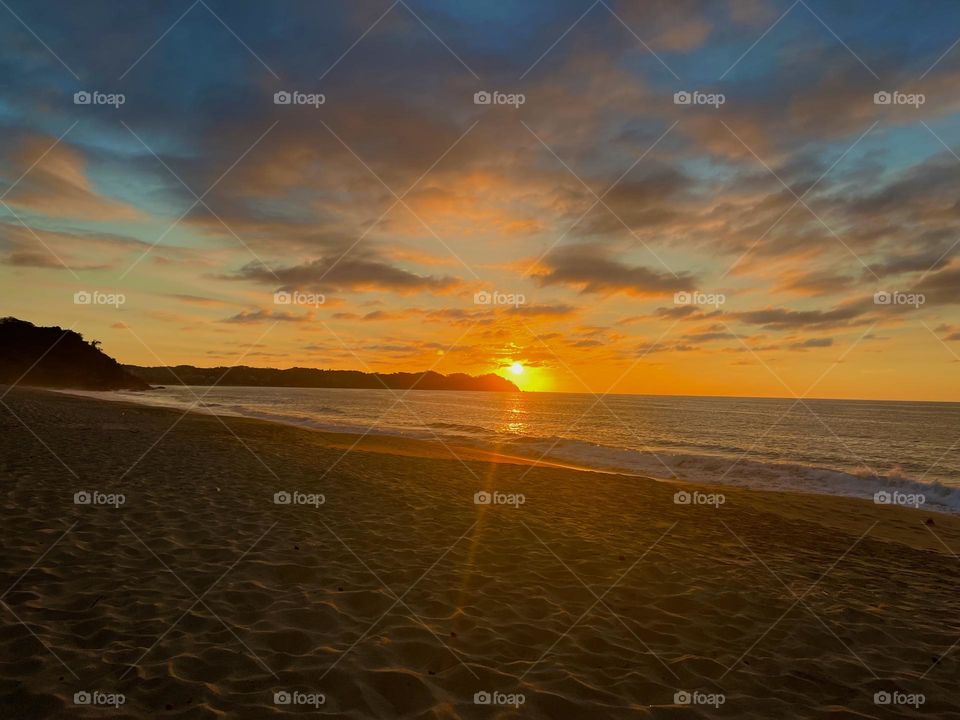 Atardecer en la playa y cielo azul 