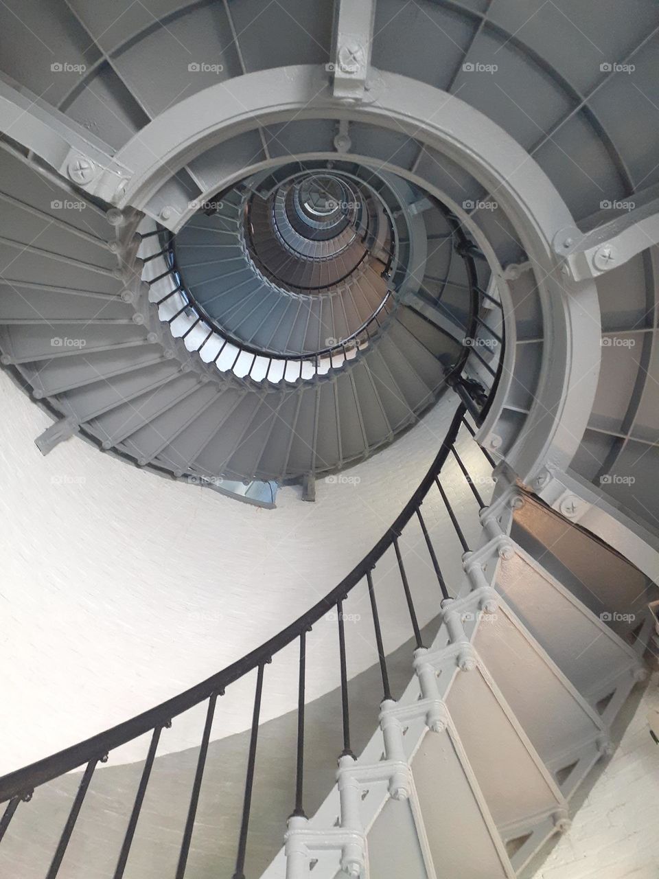 A photo of the steep spiral staircase of the Ponce Inlet Lighthouse taken from below.