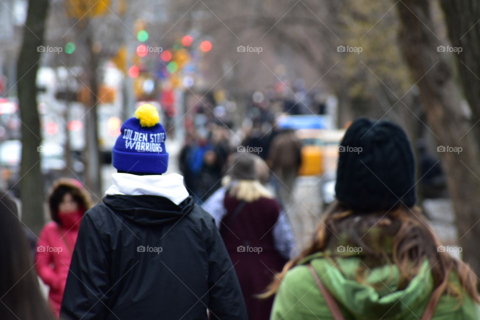 golden state warriors beanie in the middle of new York city, walking next to the grand central park.