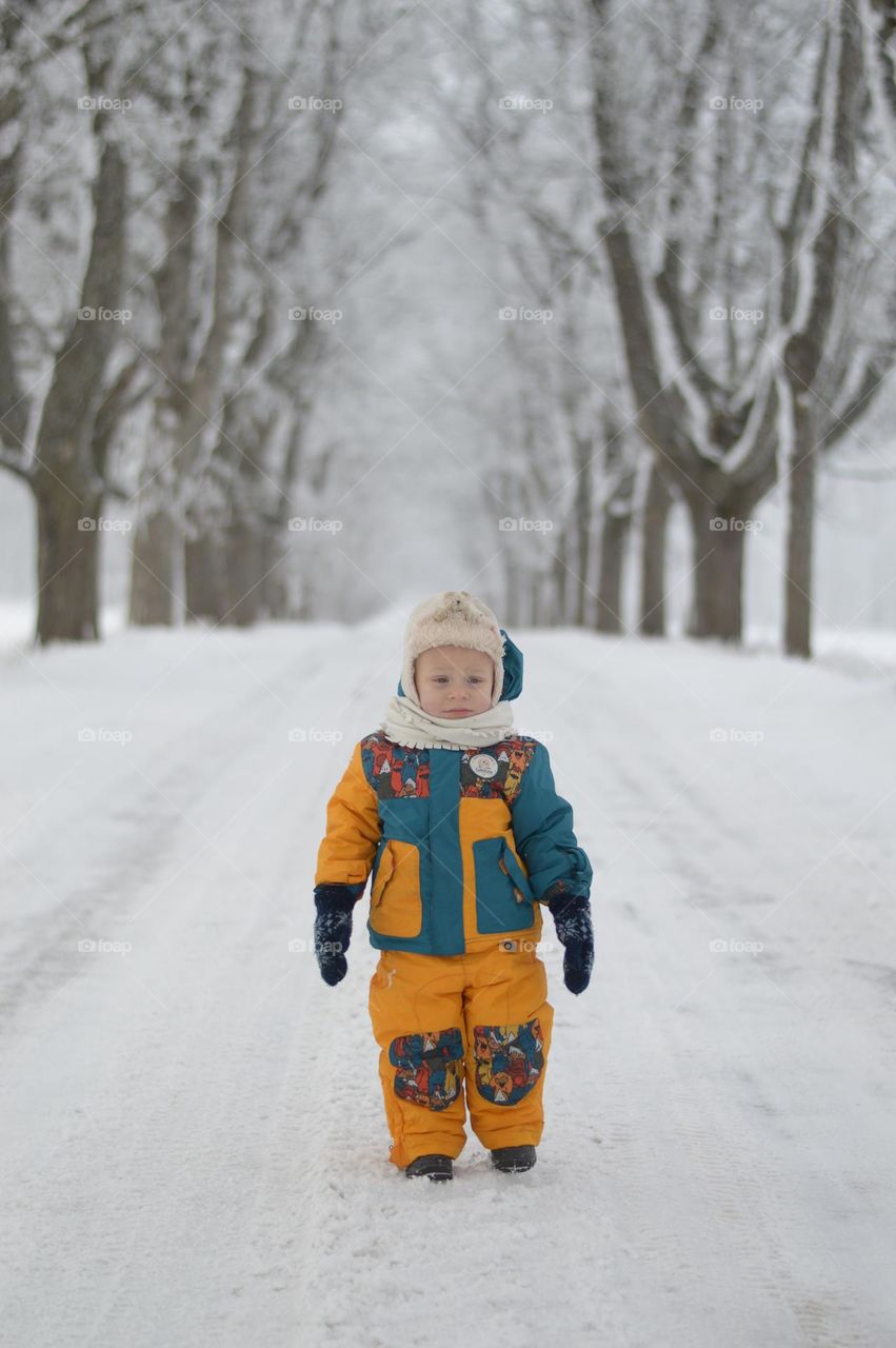 boy standing in the snowy alley