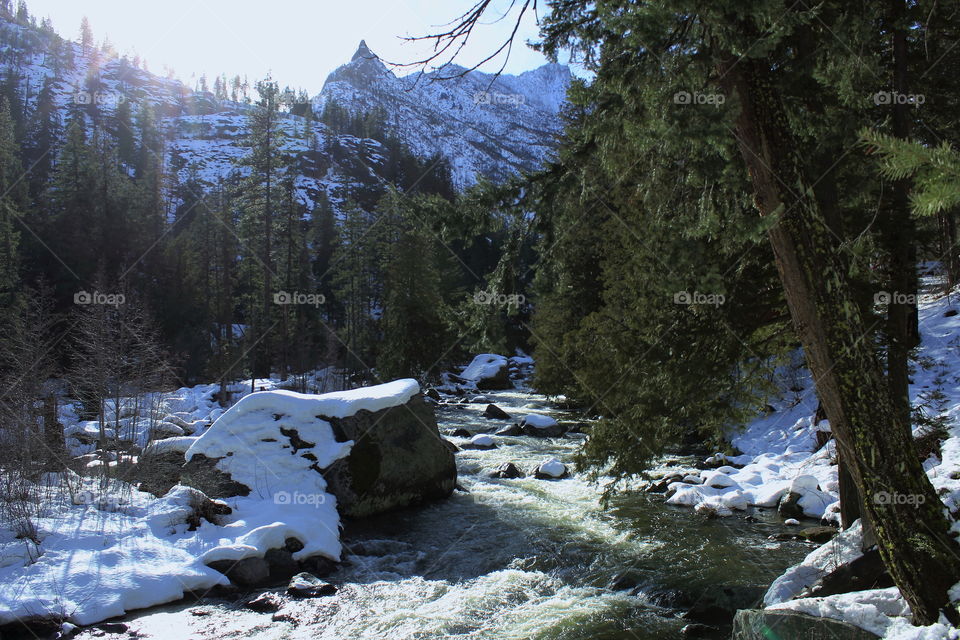Mountain stream with snow covered peak in the background 