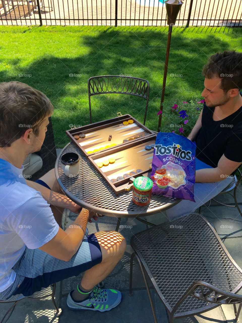 Two man playing backgammon in garden