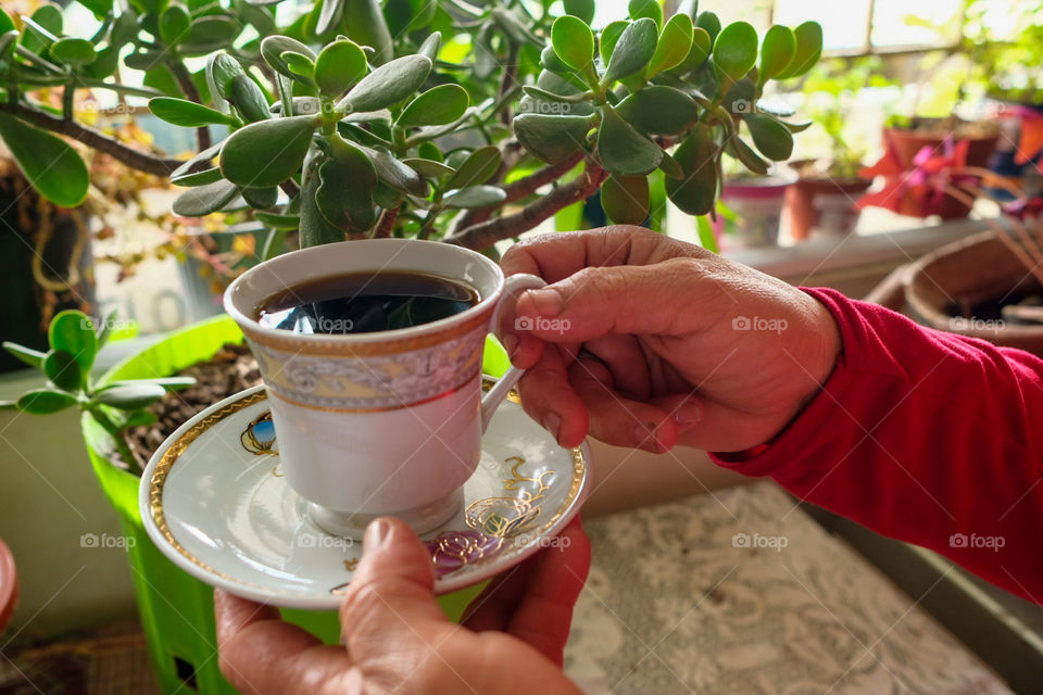 Hands invite you to have a white cup of coffee