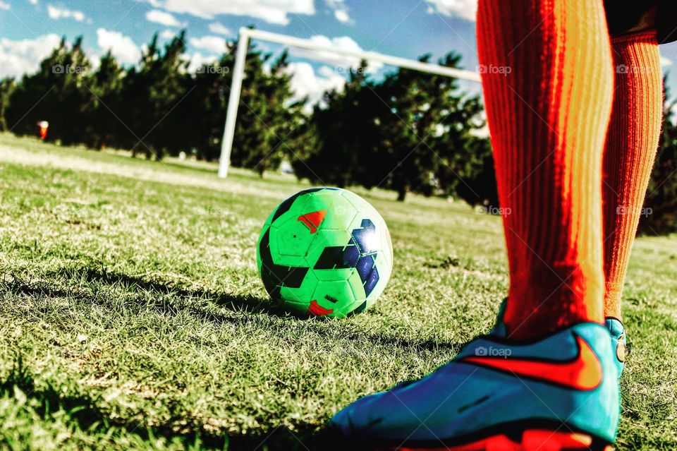 Kicking the soccer ball.