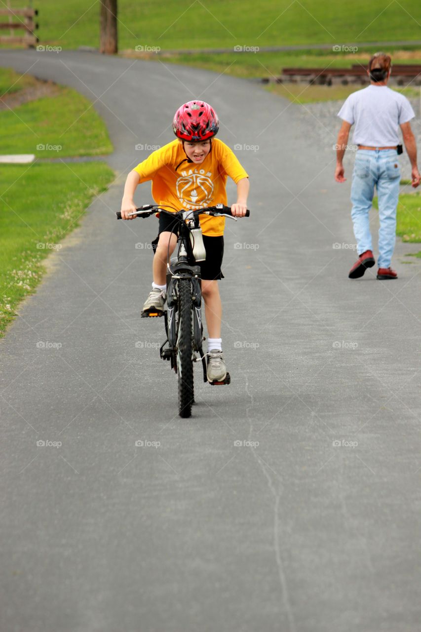 Boy wearing helmet riding bicycle