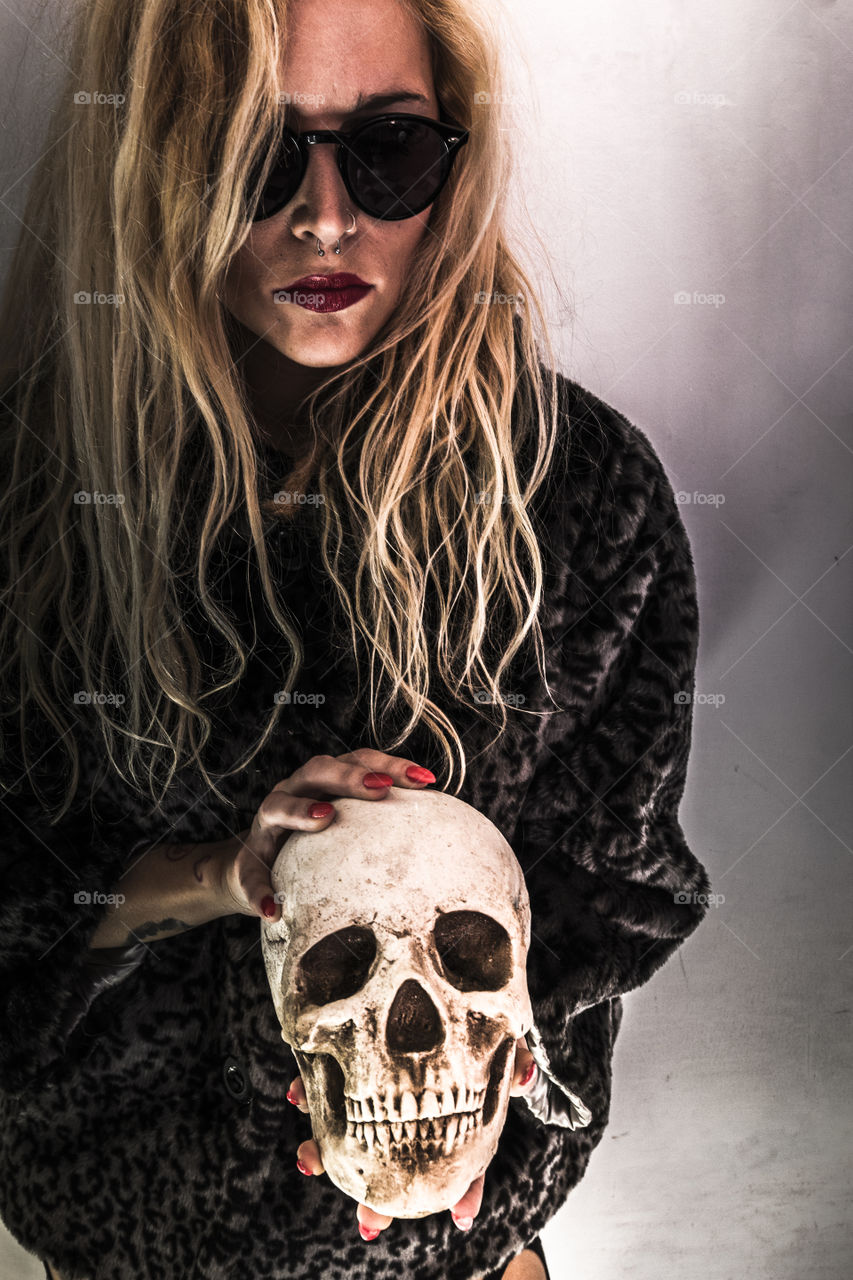 Blonde woman holding human skull