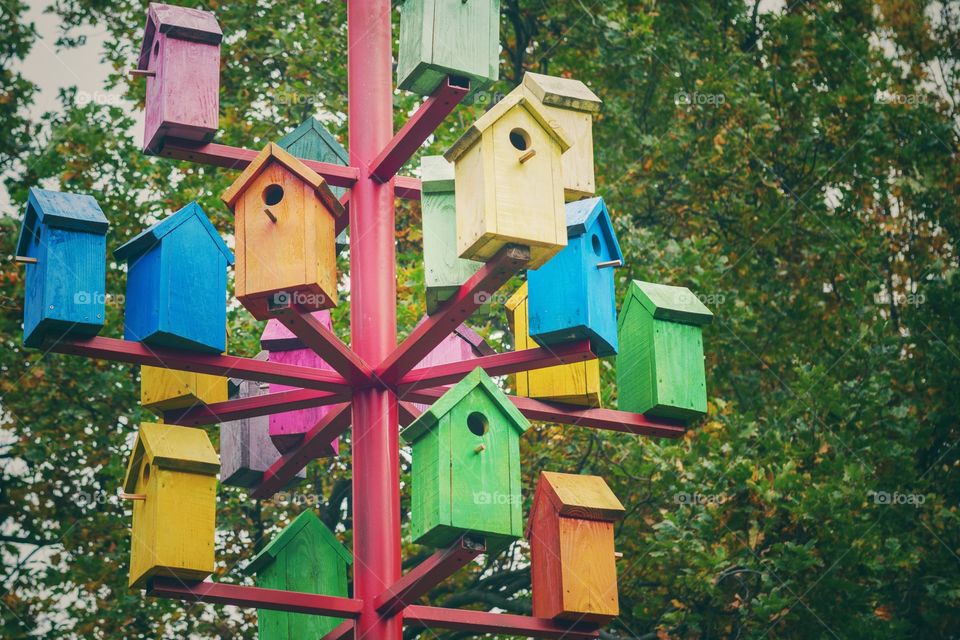 Lots of colorful nesting boxes. Many bright colored birdhouses