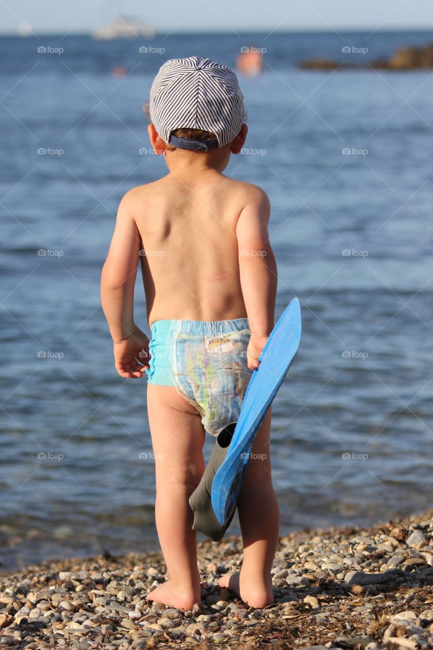 kid on the beach going tout swim
