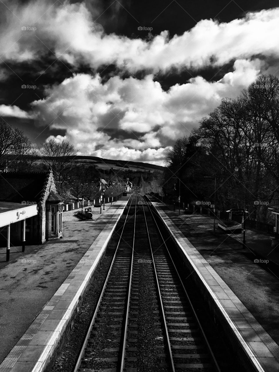 Empty railway track against cloudy sky
