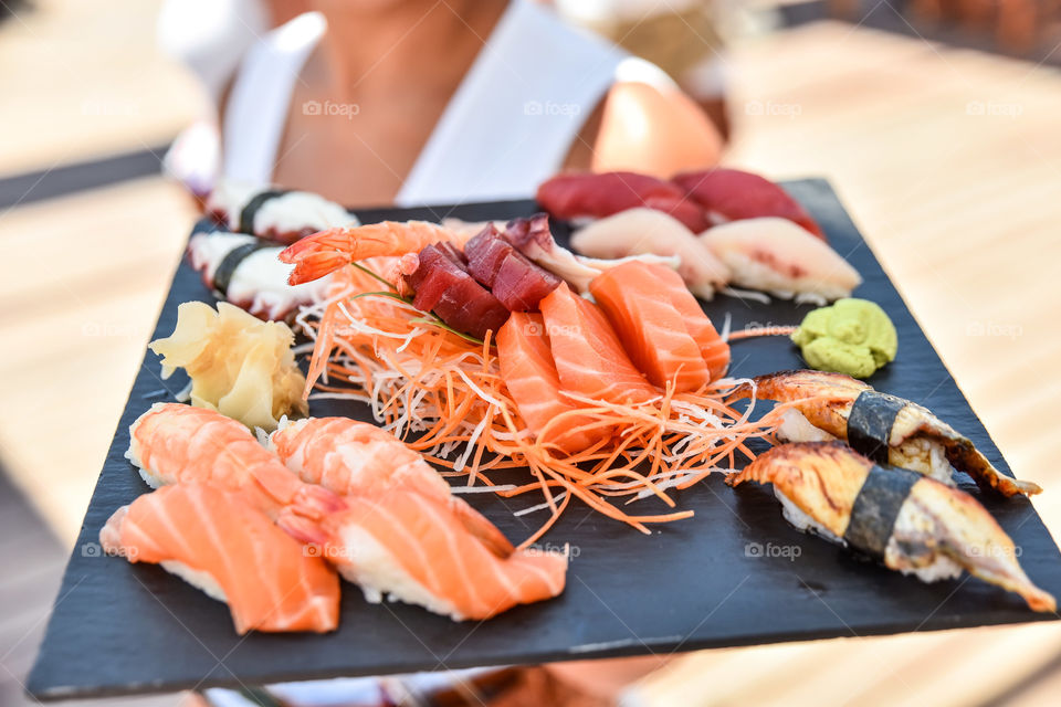 Person showing sushi dish