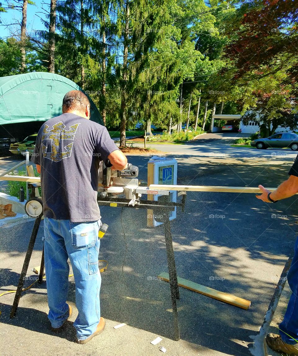 Working on saw cutting wood.