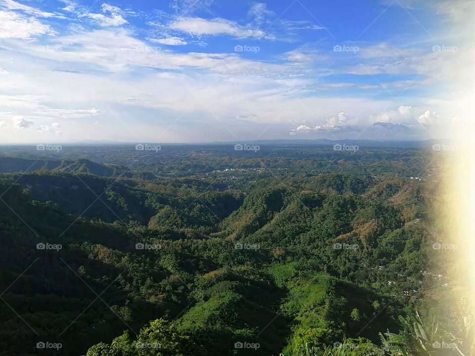 The blue sky in the distance can be seen through the gap of the mountain, it seems that in a natural and heavenly place, standing on the hill, I want to dream of touching the sky.