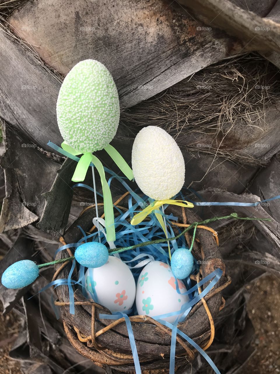 Easter eggs in the bird nest basket in the tree 