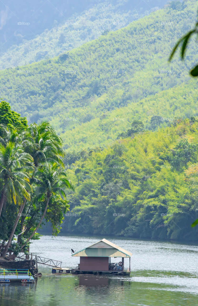 A floating raft In Kwai Yai River The background trees and mountains , Kanchanaburi in Thailand.